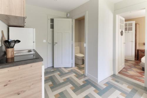 una cucina con pareti bianche e un pavimento con piastrelle geometriche di Le Petit Eloi a Saint-Gervais-les-Bains
