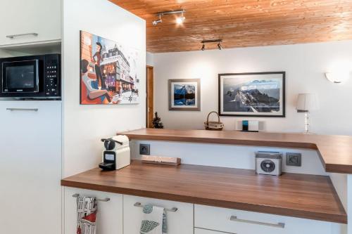 - une cuisine avec un comptoir et un four micro-ondes dans l'établissement Les Marmottes - Renovated and cozy apart - View of the mountains, aux Houches