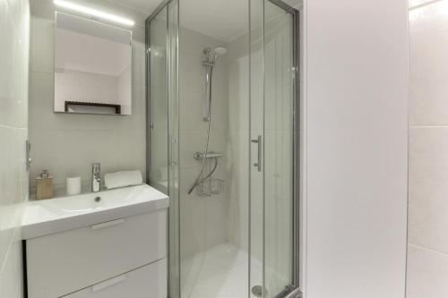 une salle de bain blanche avec une douche et un lavabo dans l'établissement Vallot - Chamonix Centre, à Chamonix-Mont-Blanc