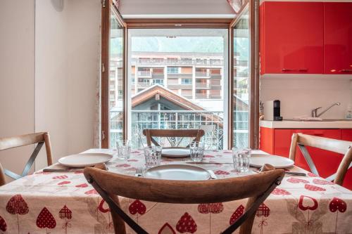 une salle à manger avec une table et une grande fenêtre dans l'établissement Les Alpes 3 - Central - Rénové - Vue sur la chaîne du Mont-Blanc, à Chamonix-Mont-Blanc
