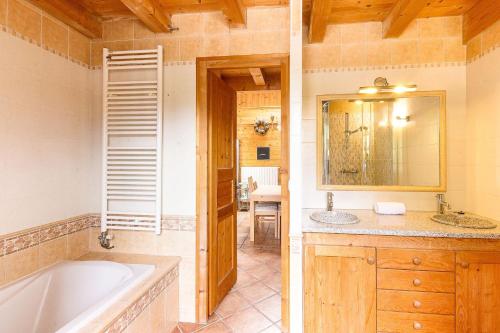 une salle de bain avec une baignoire et un lavabo dans l'établissement L'Ecrin des Pècles - Centrale - Rénové - Immense Terrasse Face au Mont-Blanc, à Chamonix-Mont-Blanc