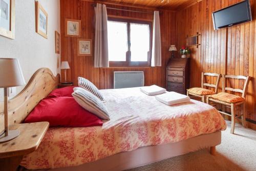 Schlafzimmer mit einem Bett, einem Schreibtisch und einem TV in der Unterkunft The Historic Chalet Les Allognes Mont-Blanc views in Les Houches