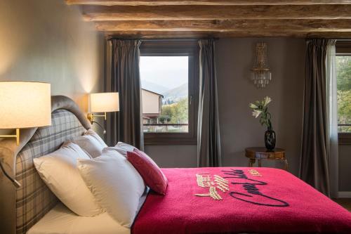 1 dormitorio con 1 cama con manta roja en Casa Valdo Country House, en Valdobbiadene