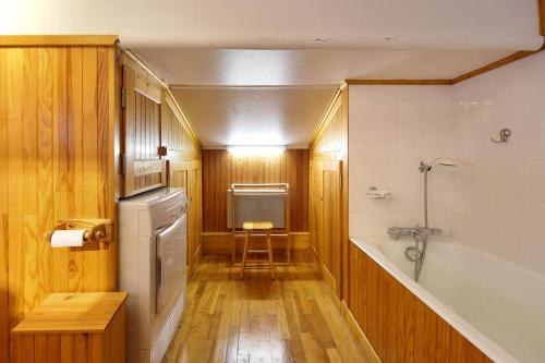 ein Badezimmer mit einer Badewanne und einem Waschbecken in der Unterkunft The Historic Chalet Les Allognes Mont-Blanc views in Les Houches