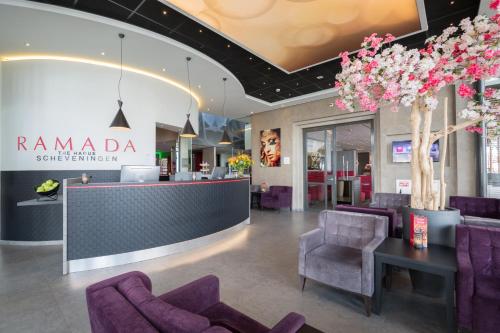 - un hall avec des chaises violettes et une réception dans l'établissement Ramada The Hague Scheveningen, à Scheveningen