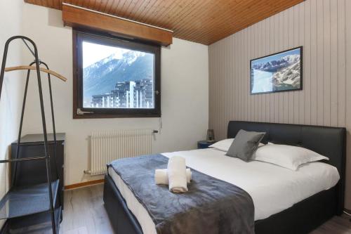 une chambre avec un grand lit et une fenêtre dans l'établissement L'Aiguille - Center of Chamonix - View Mont-Blanc, à Chamonix-Mont-Blanc