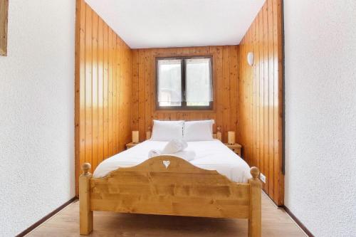 une chambre avec un lit dans une pièce avec une fenêtre dans l'établissement La Griaz - Chaleureux et cosy -Vue sur les montagnes - grand balcon, aux Houches