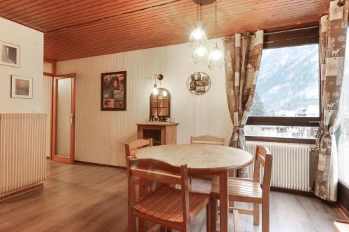 une salle à manger avec une table et des chaises et une fenêtre dans l'établissement L'Aiguille - Center of Chamonix - View Mont-Blanc, à Chamonix-Mont-Blanc