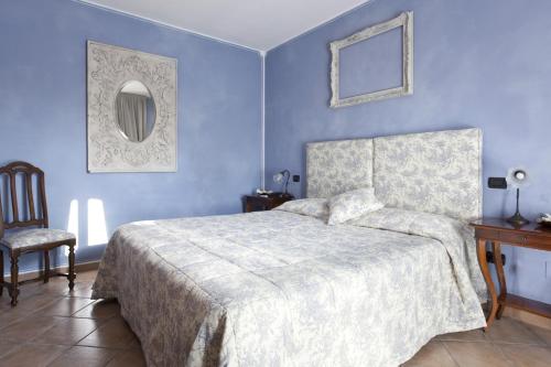 a blue bedroom with a bed and a chair at Villa Castelletto in Castelletto Molina