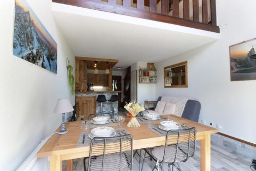 une salle à manger avec une table et des chaises en bois dans l'établissement Le Crêtet Mont-Blanc, à Chamonix-Mont-Blanc
