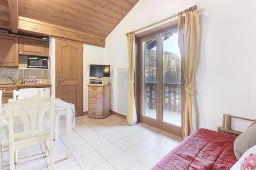 Il comprend une cuisine et un salon avec une table et une fenêtre. dans l'établissement Le Goûter - Ski-in ski-out - Indoor Pool, aux Houches