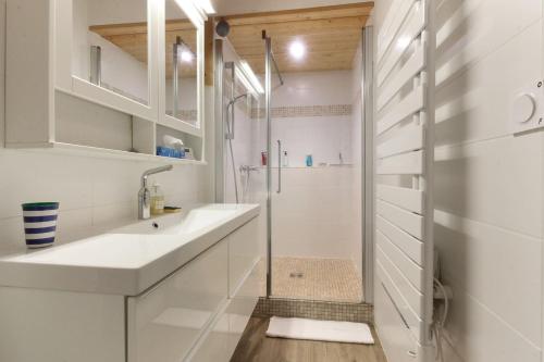 ein weißes Bad mit einer Dusche und einem Waschbecken in der Unterkunft Saint Éloi - Panoramic view - Mont Joly - Central in Saint-Gervais-les-Bains