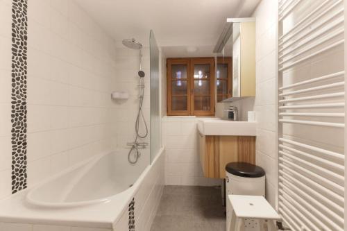 a bathroom with a tub and a toilet and a sink at Les Alpins - Centre de Chamonix - Rénové avec Jardin et vue imprenable sur le MontBlanc in Chamonix-Mont-Blanc