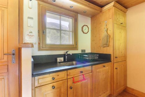 une cuisine avec un évier et une fenêtre dans l'établissement Maison Neuve - Grand appartement- Terrasse - Vue sur la vallée du Mont-Blanc, aux Houches