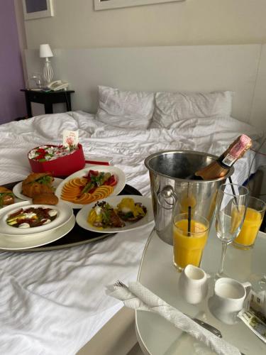 a tray with plates of food and drinks on a bed at Design Hotel Skopeli in Odesa