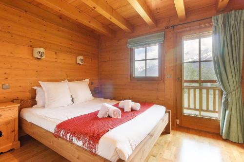 une chambre avec un lit avec des serviettes dessus dans l'établissement Maison Neuve - Grand appartement- Terrasse - Vue sur la vallée du Mont-Blanc, aux Houches