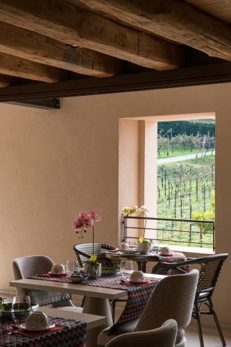 a dining room with a table and chairs and a window at Casa Valdo Country House in Valdobbiadene