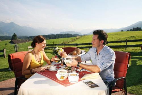 オフターシュヴァングにあるLandhotel Alphornのテーブルに座っている男性と女性