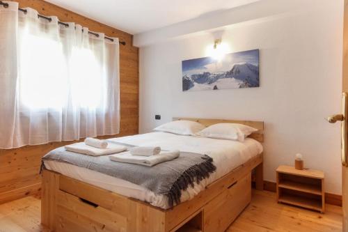 une chambre avec un lit avec des serviettes dessus dans l'établissement Les Granges des Bossons, à Chamonix-Mont-Blanc