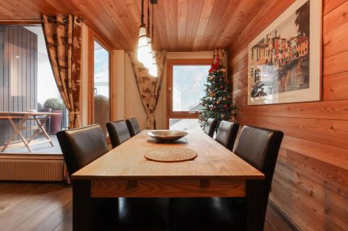 une salle à manger avec une table en bois et un arbre de Noël dans l'établissement L'Outa - Center of Chamonix - Mont-Blanc view, à Chamonix-Mont-Blanc