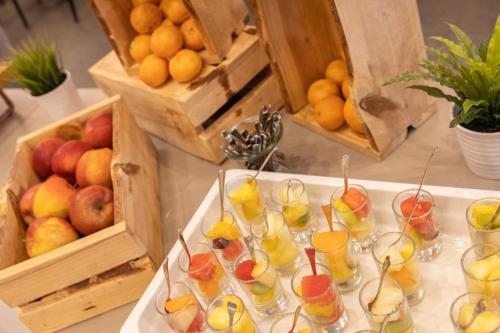 a table with glasses of fruit and a crate of oranges at Ramada The Hague Scheveningen in Scheveningen