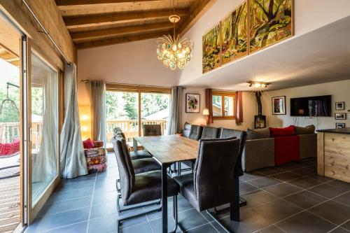 une salle à manger et un salon avec une table et des chaises dans l'établissement Delys - Renovated - Beside Park - Climbing wall - Hikes - Mont-Blanc views, aux Houches