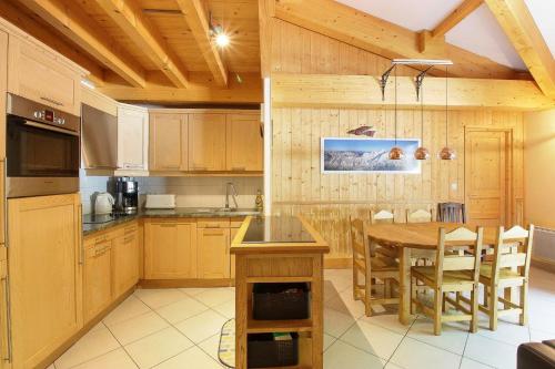 une cuisine avec des armoires en bois et une table en bois dans l'établissement Le Quatre - 75m2 Charmant Duplex - Central - 8-10 pax 3ch, à Saint-Gervais-les-Bains