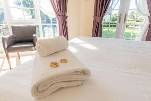 a pile of towels sitting on top of a bed at The Dewdrop Inn in Worcester