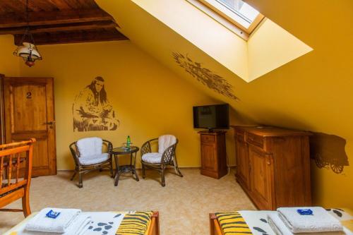 a room with a table and chairs and a tv at Penzion Country Steak Restaurant in Lanškroun