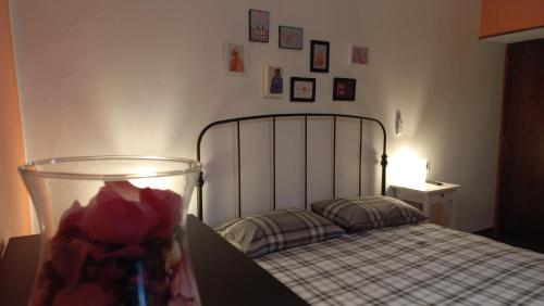 Un dormitorio con una cama y un jarrón con una flor en IL MERLO CODERLO en Scorcetoli