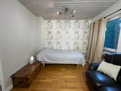 Cette petite chambre comprend un lit et un canapé. dans l'établissement Stockholm-Arlanda privat rum i rymlig villa gratis wifi 1Gb fiber parkering Room1, à Täby