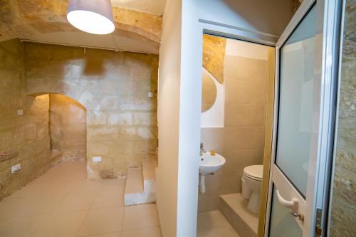 a bathroom with a toilet and a sink at Carmelita Maisonette Valletta in Valletta