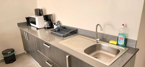 a kitchen counter with a sink and a microwave at Number 5, Pebble Bay Appartments in Grand Baie