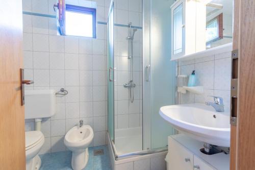 a bathroom with a sink and a toilet and a shower at Apartments Antica with a balcony in Baška