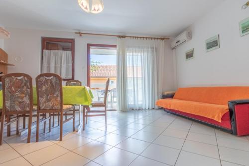 a living room with a couch and a table and chairs at Apartments Antica with a balcony in Baška