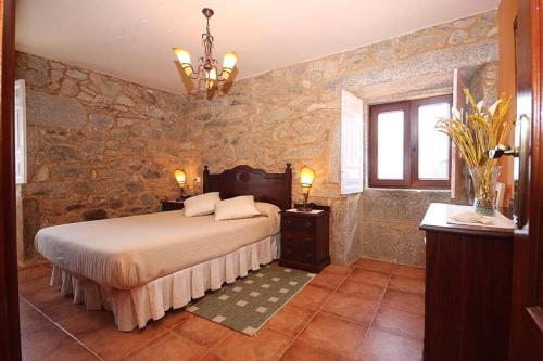 una camera con letto e parete in pietra di Casa Agrelo Ria de Noia 