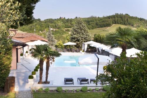 a large swimming pool with palm trees and umbrellas at Villa Castelletto in Castelletto Molina