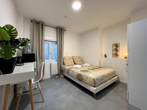 Schlafzimmer mit einem Bett, einem Schreibtisch und einem Fenster in der Unterkunft Gamma - studio 2 pers - centre / proche hôpital in Montereau-faut-Yonne