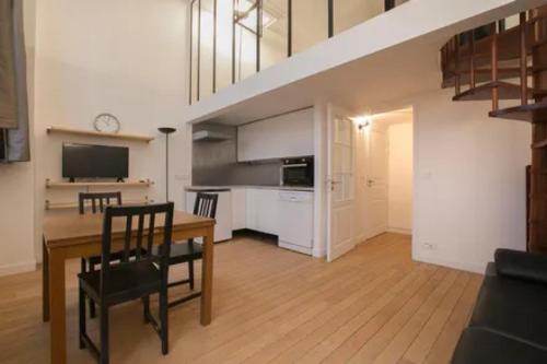 une cuisine et une salle à manger avec une table et un escalier dans l'établissement Love in marais, à Paris