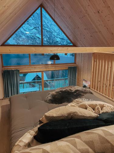 a bed in a room with a large window at Lofoten Cabins in Hopen