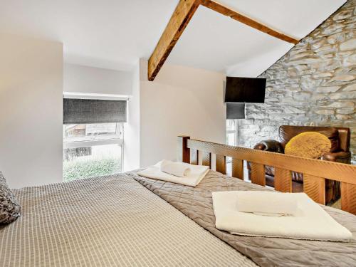 a bedroom with a large bed with a stone wall at 2 bed in Tregaron 89010 in Tregaron