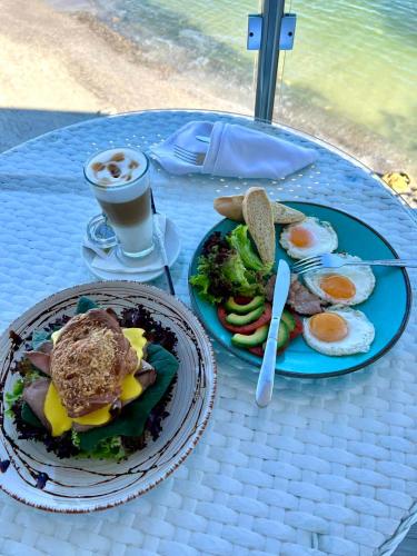 a table with two plates of food and a cup of coffee at Design Hotel Skopeli in Odesa