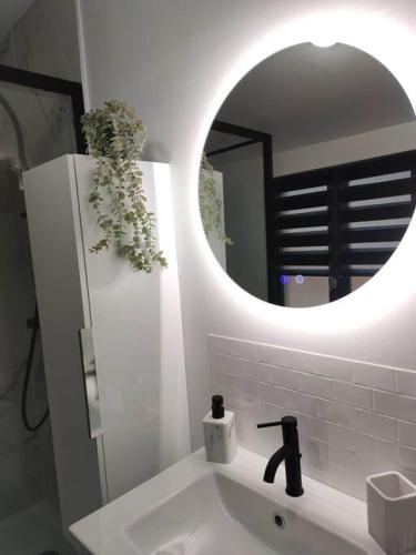 une salle de bain blanche avec un lavabo et un miroir dans l'établissement L'évasion du Coquelicot, à Albert