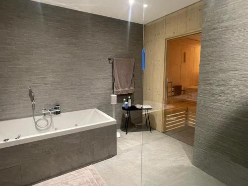 La salle de bains est pourvue d'une baignoire et d'une douche. dans l'établissement Berghof, à Saas-Fee