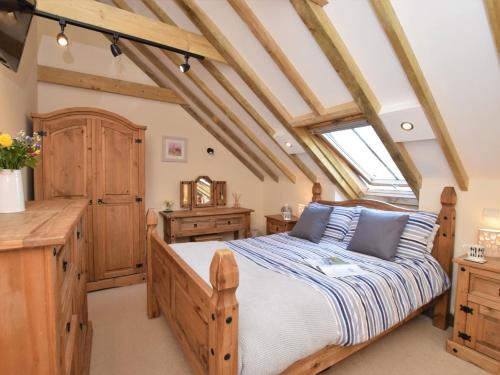 a bedroom with a wooden bed and a window at 2 Bed in Widemouth Bay WOOWW in Poundstock