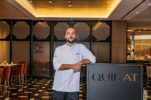 a man standing next to a sign in a restaurant at InterContinental Barcelona by IHG in Barcelona