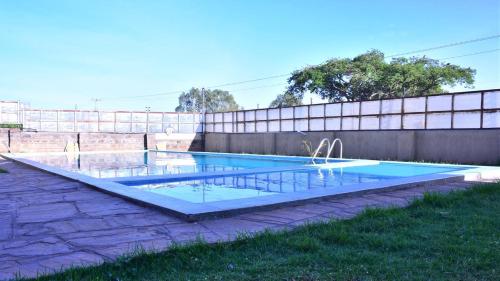 a swimming pool in a yard with a fence at Essy's Furnished Homes Nakuru with pool & GYM in Nakuru