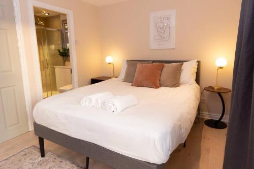 um quarto com uma grande cama branca com toalhas em Beautiful West Didsbury 4BR Home em Manchester