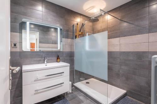 une salle de bain avec un lavabo et un miroir dans l'établissement SmartStay Le Thiou - Annecy centre, à Annecy