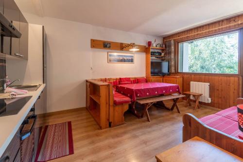 un salon avec une table et un canapé rouge dans l'établissement SmartStay Couttet Champion - Chamonix, à Chamonix-Mont-Blanc